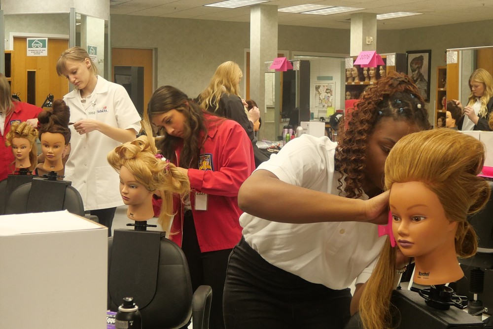 Cosmetology students working on mannequins